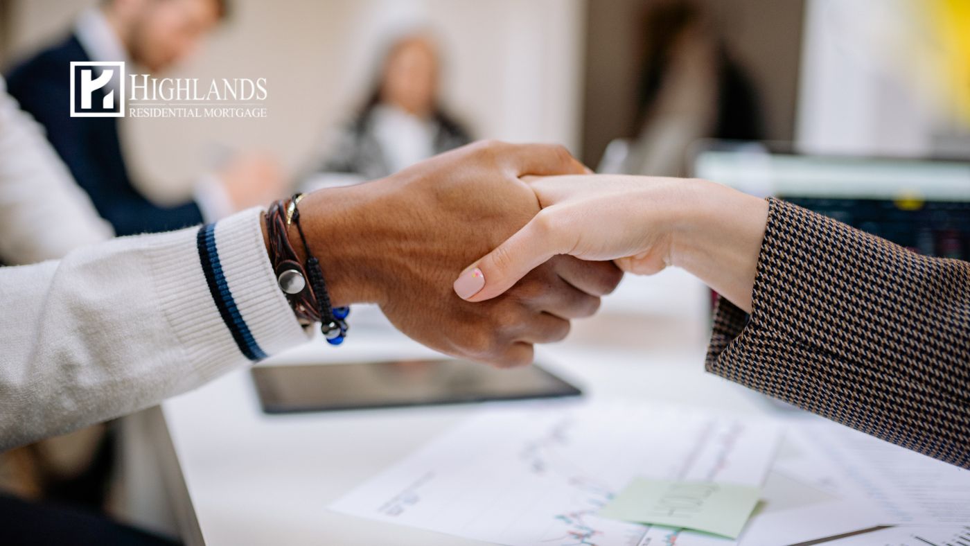 closing costs in 2026 — homebuyer and mortgage professional shaking hands at closing table